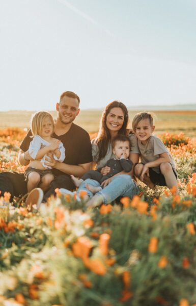 Photo d'une famille avec 3 enfants dans un champ de fleurs