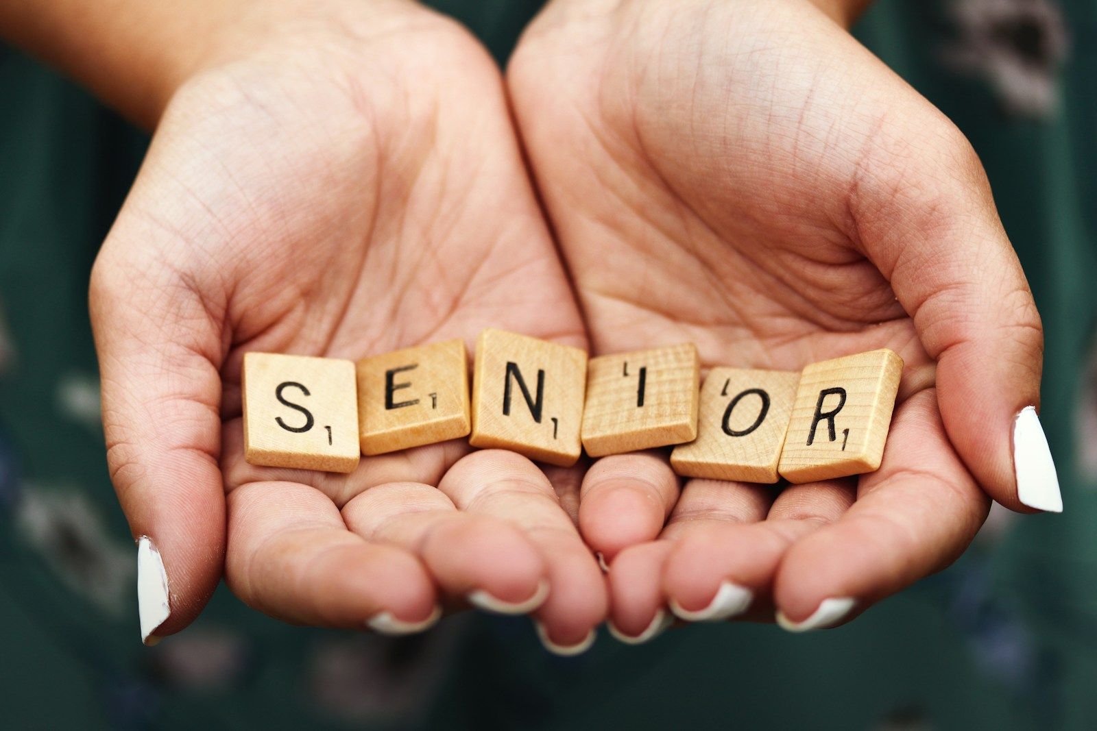 lettres de scrabble senior sur les mains d'une personne