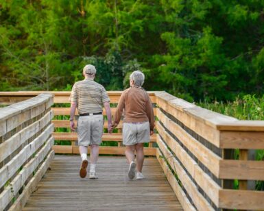 Un couple de personne âgées marchant main dans la main