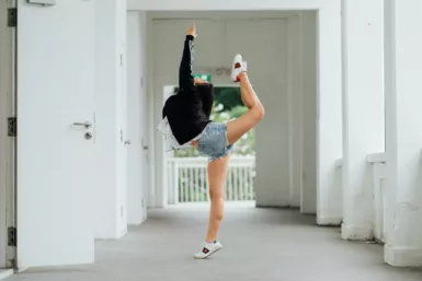 Femme en tenue de sport faisant un mouvement de danse