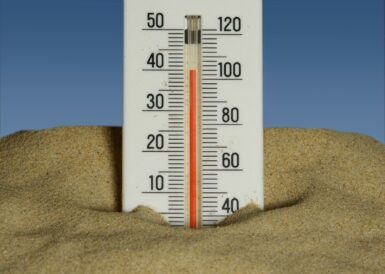 Thermomètre enfoncé dans le sable en pleine canicule