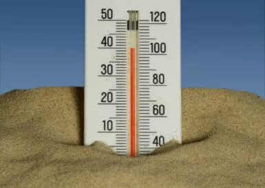 Thermomètre enfoncé dans le sable en pleine canicule
