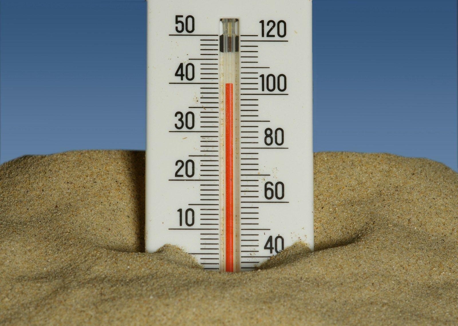 Thermomètre enfoncé dans le sable en pleine canicule